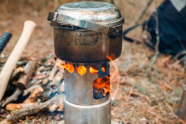 kamp woodstove ve mutfak eşyaları, balta ve mayın bir çeşidinde kürek ve arka plan üzerinde sırt çantası