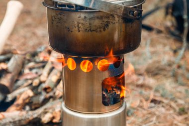 kamp woodstove ve mutfak eşyaları, balta ve mayın bir çeşidinde kürek ve arka plan üzerinde sırt çantası