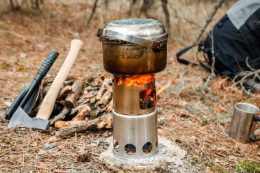 kamp woodstove ve mutfak eşyaları, balta ve mayın bir çeşidinde kürek ve arka plan üzerinde sırt çantası