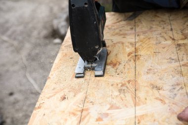 bir Jigsaw ile bir OSB paneli kesme, panelde el