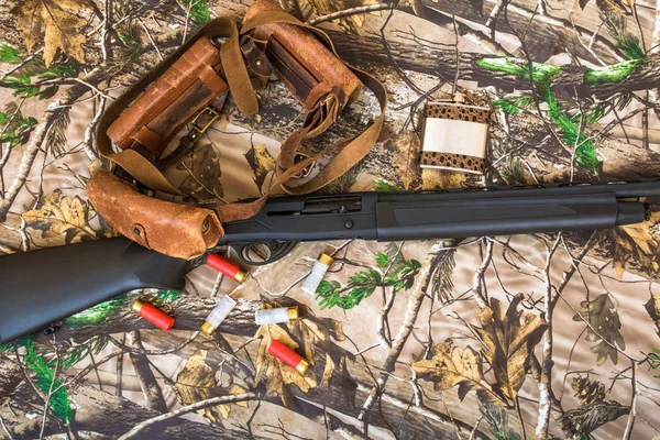 Αυτόματη κυνηγετικό όπλο, θήκη φυσιγγιων και μεταλλική φιάλη για το φόντο του καμουφλάζ — Φωτογραφία Αρχείου