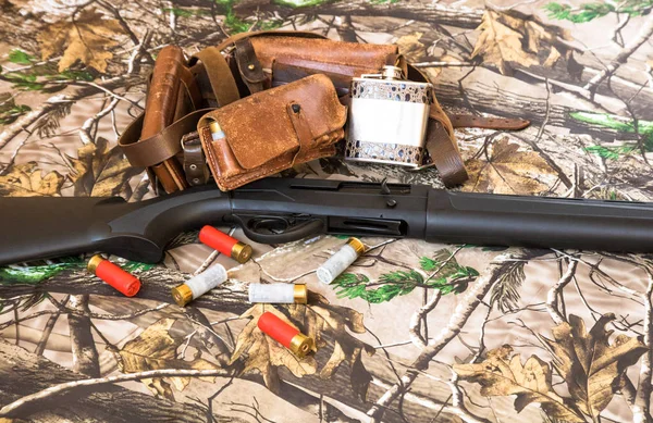 自动猎枪, 弹药筒带和金属瓶在伪装背景 — 图库照片