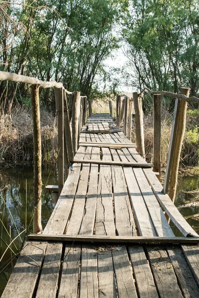 Viejo puente de tablón de madera en ruinas a través del río — Foto de Stock