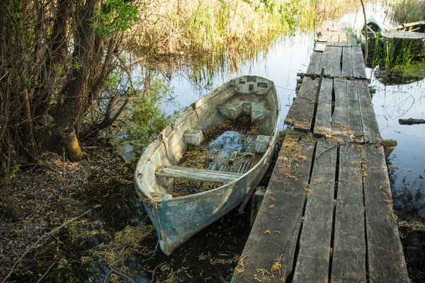 Vieux bateau en bois près de planche poste à quai délabré — Photo