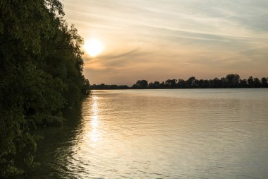 nehir üzerinde bulutlar ile turuncu gün batımı