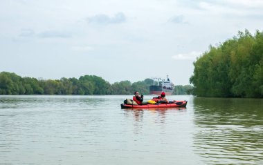 geniş nehir üzerinde kürek kayıklar sefer, arka planda bir bi gemi. 28/04/2019. Tuna. Ukrayna/Romanya