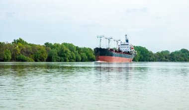 Tuna Nehri üzerinde büyük kırmızı kargo gemisi yelken