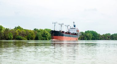 Tuna Nehri üzerinde büyük kırmızı kargo gemisi yelken