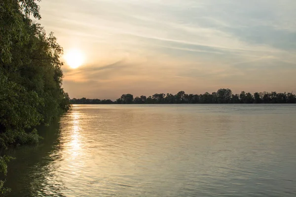 Coucher de soleil orange à travers les nuages sur la rivière — Photo