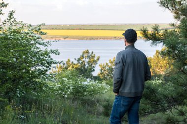gölde gün batımında izlerken ormanda kap adam