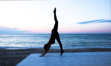 tanınmaz kadın denizde gün doğumunda yoga yapıyor, yoga silueti pozlar