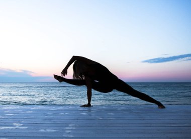 tanınmaz kadın denizde gün doğumunda yoga yapıyor, yoga silueti pozlar