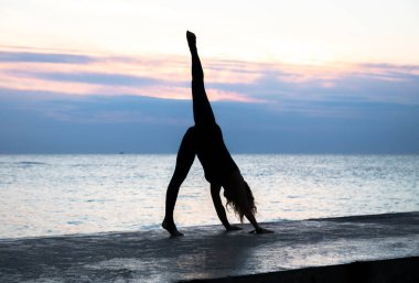güzel vücut profissiionally denizde gün doğumunda yoga yapıyor tanınmayan senoir kadın, yoga silueti pozlar