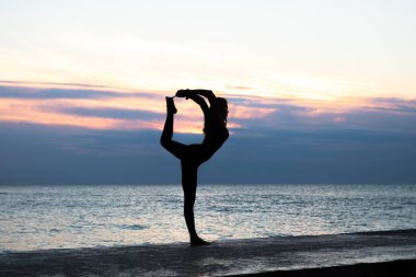 güzel vücut profissiionally denizde gün doğumunda yoga yapıyor tanınmayan senoir kadın, yoga silueti pozlar