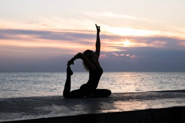 denizde gün doğumunda yoga böler yapıyor güzel vücut ile tanınmaz senoir kadın, yoga silueti pozlar