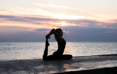 denizde gün doğumunda yoga böler yapıyor güzel vücut ile tanınmaz senoir kadın, yoga silueti pozlar