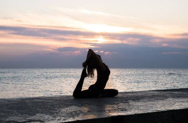 denizde gün doğumunda yoga böler yapıyor güzel vücut ile tanınmaz senoir kadın, yoga silueti pozlar