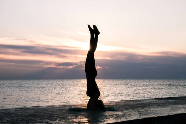 denizde gün doğumunda yoga headstand yapıyor güzel vücut ile tanınmaz kadın, yoga silueti pozlar