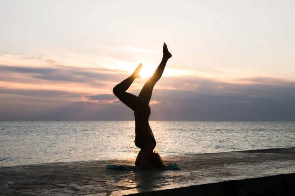 denizde gün doğumunda yoga headstand yapıyor güzel vücut ile tanınmaz kadın, yoga silueti pozlar