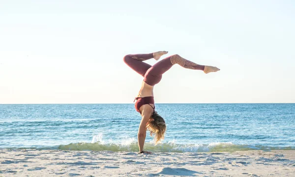 Kaukaski zdrowe dorosły kobieta z pięknym ciałem robi jogę na wschodzie słońca na plaży, Joga stwarza — Zdjęcie stockowe