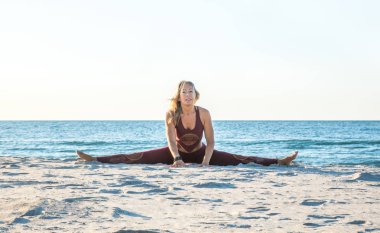 sahilde gün doğumunda yoga yapan güzel vücut ile kafkas sağlıklı yetişkin kadın, yoga pozlar