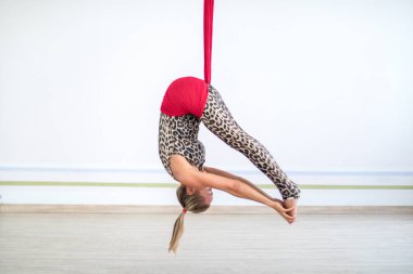 kafkas kadın kırmızı hamak beyaz yoga stüdyosunda sinek yoga egzersizleri yapıyor