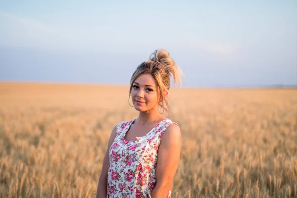 Joven seductora rural rubio cabello mujer en vestido en el campo de trigo amarillo en la puesta del sol — Foto de Stock