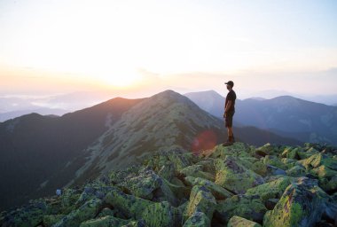 kafkas adam yürüyüşçü yeşil taşların zirvesinde dağ gün batımı ışığında dağların panoramik bir görünüm keyfini