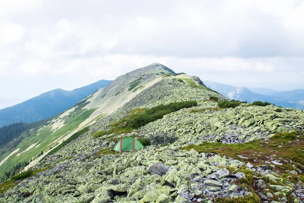 緑の大きな石で覆われた山の尾根の緑のテント — ストック写真