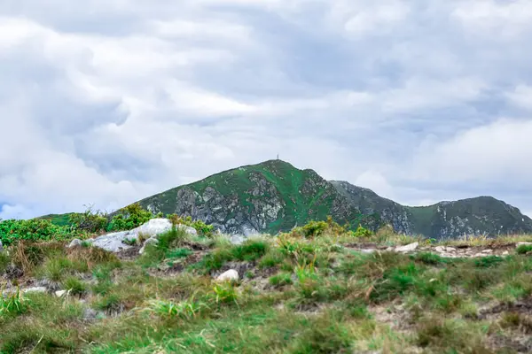 緑の山の尾根の頂上への道、山の頂上の国境ポスト — ストック写真