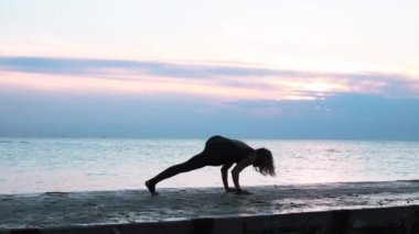 denizde gün doğumunda yoga böler yapıyor güzel vücut ile olgun kadın, yoga silueti pozlar