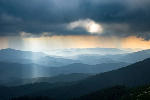 Rayon de soleil à travers les nuages orageux dans les montagnes — Photo