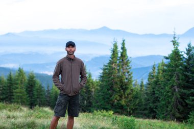 kap yürüyüşçü adam karpat dağlarda mavi sis ile kaplı dağ aralığının sahne hayran