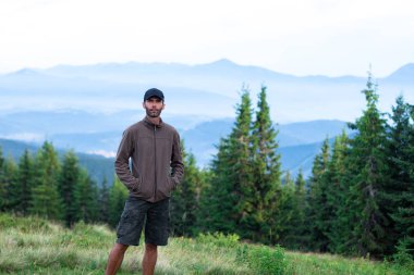 kap yürüyüşçü adam karpat dağlarda mavi sis ile kaplı dağ aralığının sahne hayran