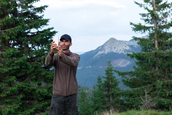 Hiker mężczyzna w czapkę robienia selfie przed górami w Karpatach Gorgany — Zdjęcie stockowe