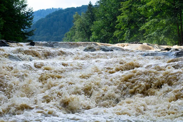 Fast stream of dirty water in river rapids and waterfall — Stock Photo, Image