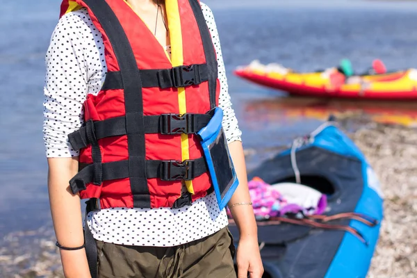 Gilet de sauvetage femme en rouge à la mer, kayaks en arrière-plan — Photo