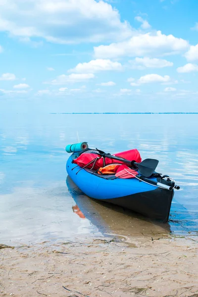 Kayak azul en la orilla del mar, agua azul suave y cielo — Foto de Stock