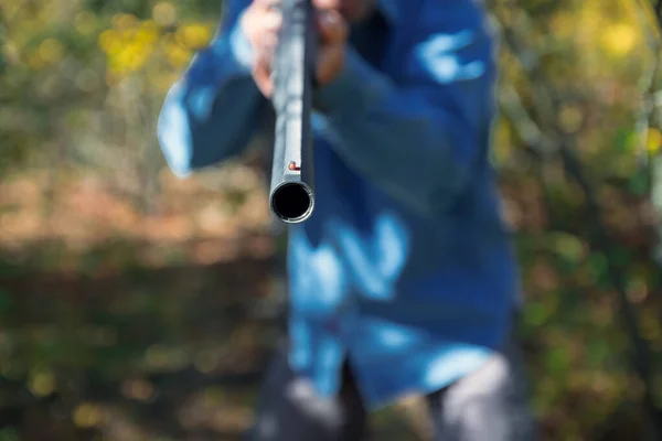 Macho con una escopeta semiautomática en el bosque de otoño apuntan con una escopeta — Foto de Stock