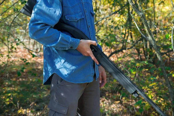 Male with semi-automated shotgun in the autumn forest — Stock Photo, Image