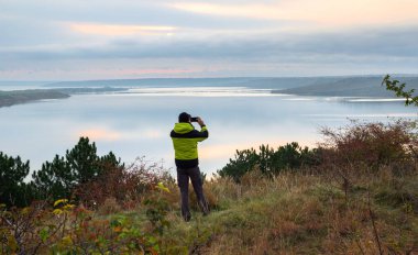 adam göl, güzel manzara fotoğrafını gündoğumu alıyor
