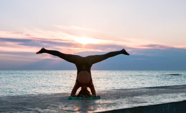 denizde gün doğumunda yoga böler yapıyor güzel vücut ile tanınmaz senoir kadın, yoga silueti pozlar