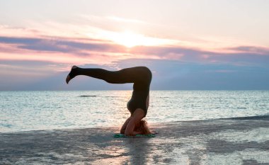 denizde gün doğumunda yoga böler yapıyor güzel vücut ile tanınmaz senoir kadın, yoga silueti pozlar