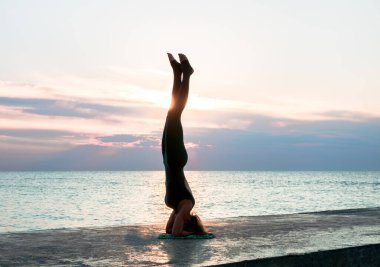 denizde gün doğumunda yoga böler yapıyor güzel vücut ile tanınmaz senoir kadın, yoga silueti pozlar