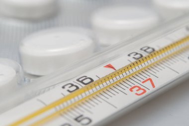 İlaç ve tıbbi termometre. Medikal termometre ve beyaz zemin üzerine hap
