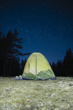 gece yıldızlı gökyüzü altında bir çadırda