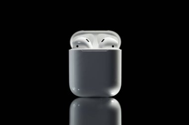 white headphones airpods on black background