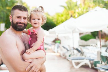 Baba ve kızı yaz havuzunda yüzüyor. 