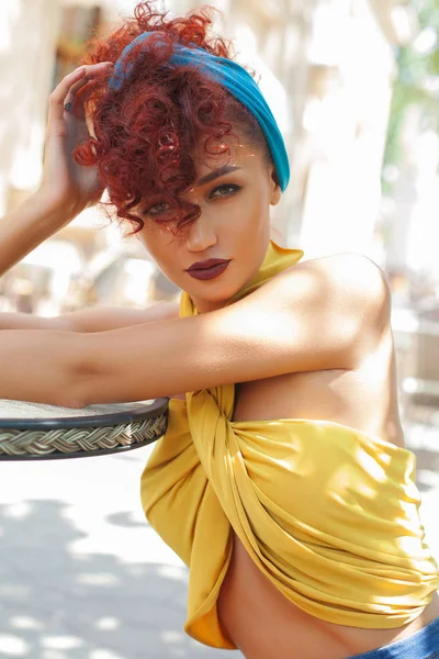 Street look of Fashion and Sexy woman with red curly hairstyle and blue turban