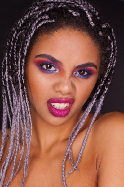 Beautiful African woman with color pigtails, fashion colorful makeup